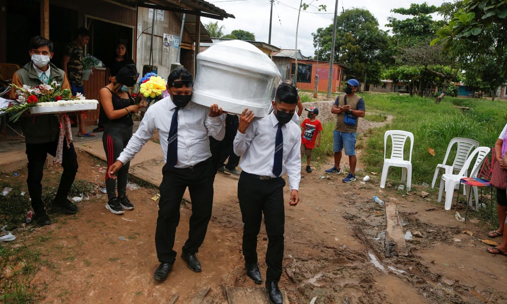 Funeral home workers carry the coffin of a coronavirus victim in Pucallpa, Peru.
