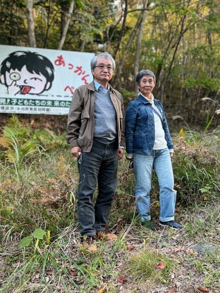 Tsuyoshi Suda, left, and Onagawa town councilor Mikiko Abe, in front of a sign opposing the local nuclear power plant.