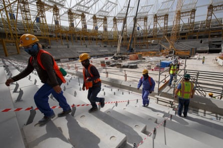 Workers walk up into the stands at the construction site for the al-Rayyan stadium.