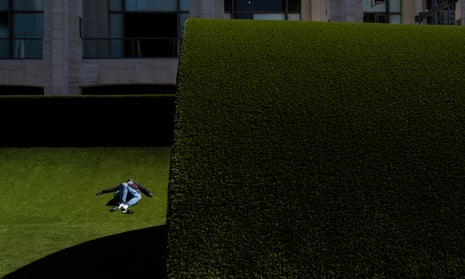 A man lies on an artificial lawn.
