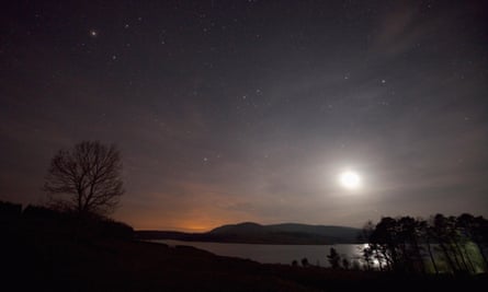 A clear sky at night over Clatteringshaws Loch