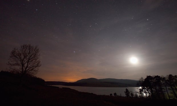 A clear sky at night over Clatteringshaws Loch, Galloway Forest Park, Dumfries and Galloway, Scotland.