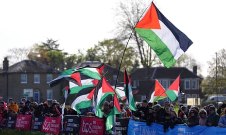 Spectators wave Palestinian flags before the London Marathon