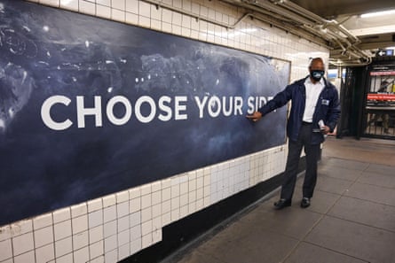 A man stands in front of a sign that says “choose your side”