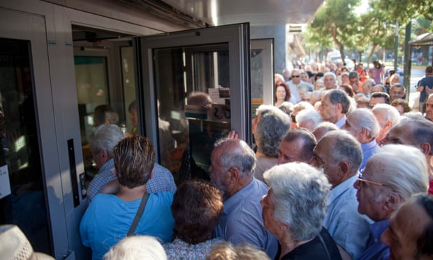 Greek people queue to enter a bank
