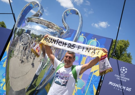 A fan poses with a giant replica of the Champions League trophy in Munich.