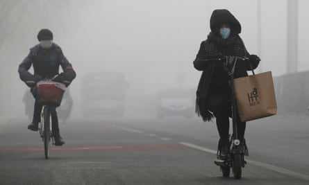 People cycle in the smog in Beijing.