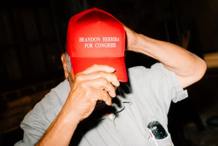 a man wears a red cap that says âÂÂBrandon Herrera for CongressâÂÂ