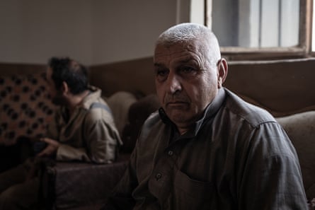 A man sits in a dark room