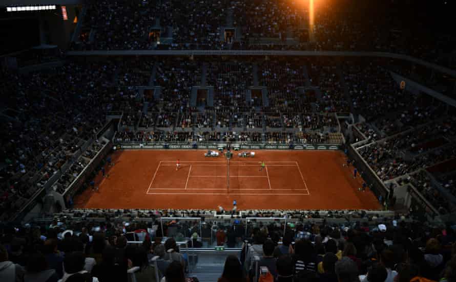 Spectators look on as Novak Djokovic and Rafael Nadal play late into the night/morning.