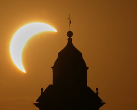 A solar eclipse is seen over a Virgin Maria church in Vidigulfo, near Pavia, northern Italy.