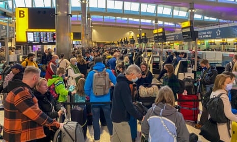 Passengers wait in queues in Terminal 2 at Heathrow