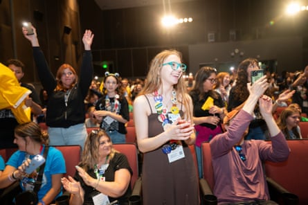 Student wearing glasses and badges stands up