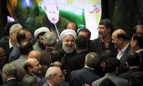 Iranian president Hassan Rouhani (center) talks with lawmakers during a session in parliament.