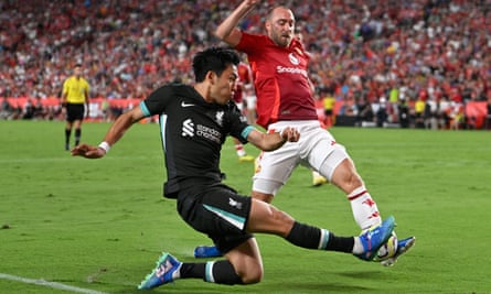 Wataru Endo challenges Christian Eriksen for the ball.