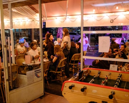 The inside of the bar, with a foosball table and people drinking and chatting