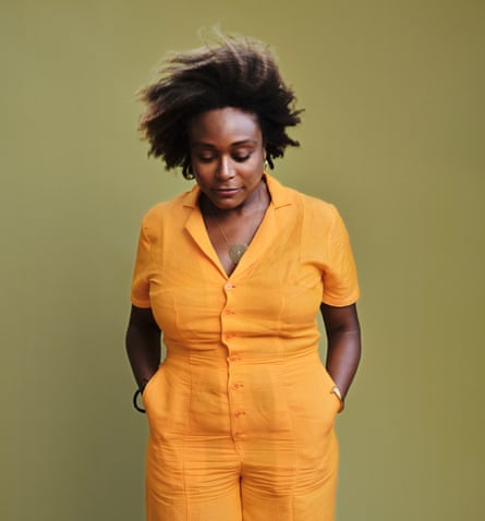 Margaret Wilkerson Sexton wearing an orange jumpsuit against a yellow wall