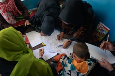 A group of women and girls doing drawings