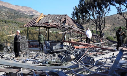 People stand at the site of a destroyed building