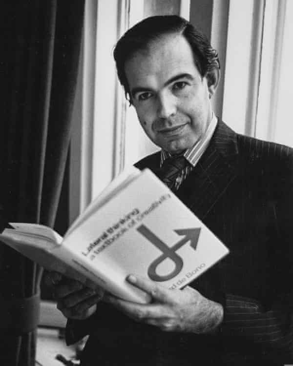 Edward de Bono in a tie and button-down collar shirt holding his book Lateral Thinking in 1974