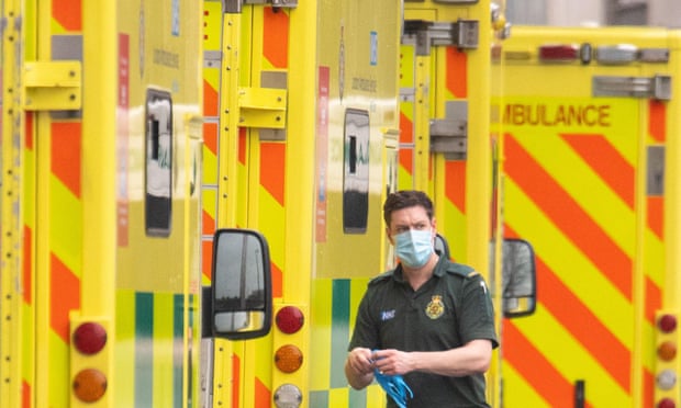A paramedic is seen with a row of ambulances outside the Royal London Hospital.