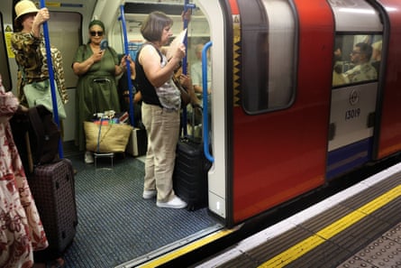 People using fans on the tube in central London on Wednesday.