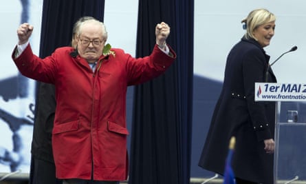 Jean-Marie Le Pen gestures on stage as Marine Le Pen looks