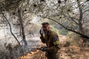 Firefighter Panagiotis Haratsis works during a wildfire at the north-east suburb of Pallini near Athens