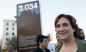Barcelona’s mayor Ada Colau poses in front a digital billboard that shows the number of refugees who died in the Mediterranean.