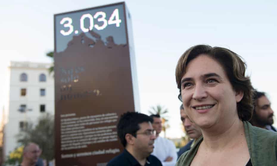 Barcelona’s mayor Ada Colau poses in front a digital billboard that shows the number of refugees who died in the Mediterranean.