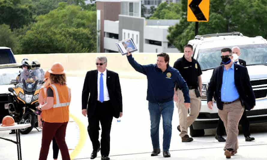 Governor Ron DeSantis waves as he and the Florida department of transportation secretary, Kevin Thibault, left, to open a new interchange in Orlando in May.