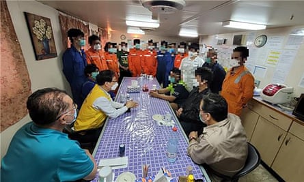 A South Korean official (wearing a yellow vest) meets crew members of the Hankuk Chemi.