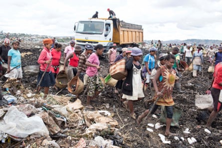 Workers rush to the next lorry dumping its load at the site.