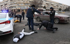 Police officers detain people in a street in Almaty.