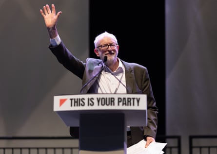 Man at podium waves to crowd.