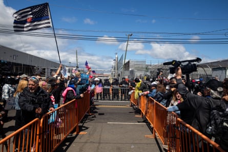 people shout at each other across metal barricades