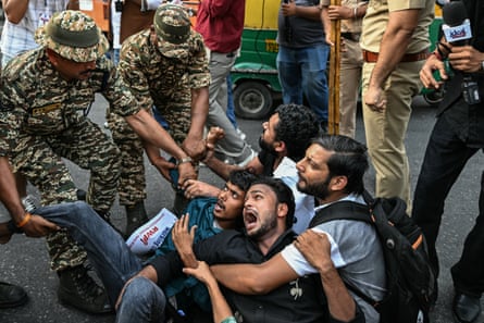 Security personnel detain demonstrators during a protest demanding the resignation of India’s chief election commissioner on Sunday.
