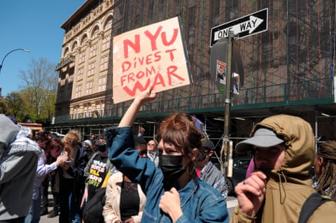 A protester holds up a sign reading 'NYU divest from war'
