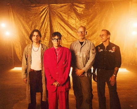 The four stand against in a brightly lit gold room