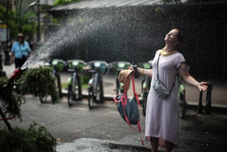 A woman cools off in front of a hose in Paris.