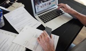 Image of man with bills doing online payment at home