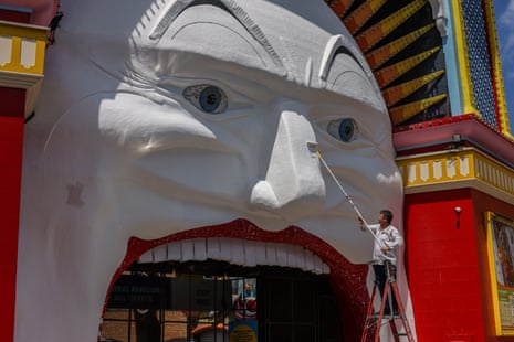 Artist Mark Ogge paints key features of Mr Moon’s face at Luna Park.