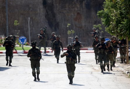 Israeli soldiers conduct patrols along the streets of Qusra