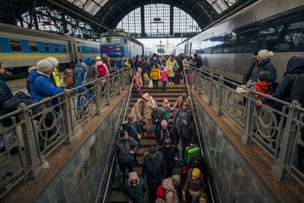 People walk down stairs from a platform at the station
