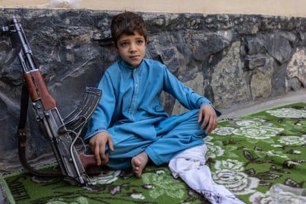 One of the sons of a Talib sits next to a gun outside a Taliban ministry in Herat.