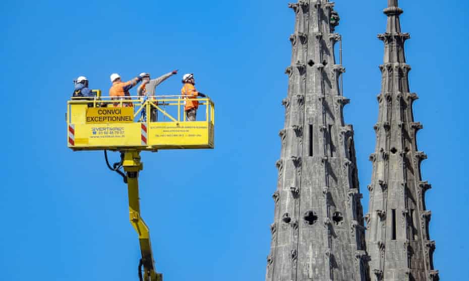 Workers and firefighters survey damage at the Notre Dame cathedral, which was ravaged by fire.