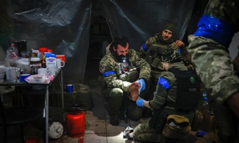 Ukrainian servicemen administer first aid to a wounded soldier in a shelter in Soledar, the site of heavy battles with Russian forces in the Donetsk region, Ukraine.