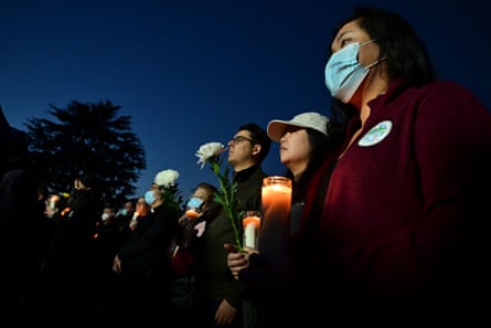 People hold candles as they pay tribute to the victims of the mass shooting during a candlelight vigil in front of City Hall in Monterey Park on Tuesday.