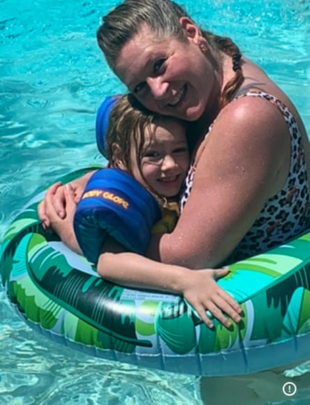 a woman hugging a young girl in a pool