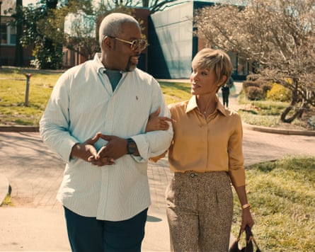 Older couple walk arm-in-arm on a sunny campus
